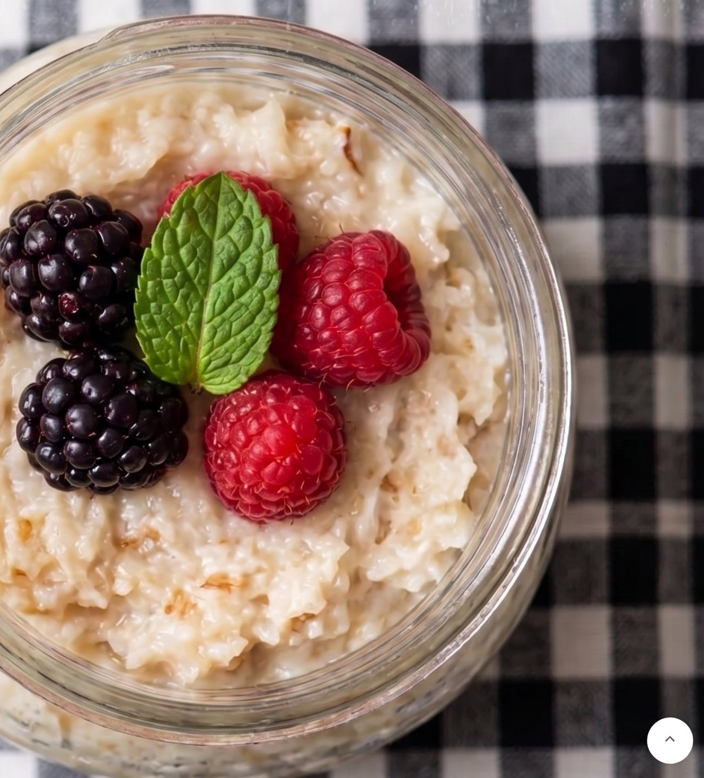 Pote de cocada de colher com frutas vermelhas sobre toalha xadrez